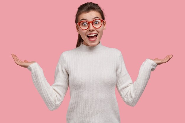 Jeune femme brune en pull blanc et lunettes rouges