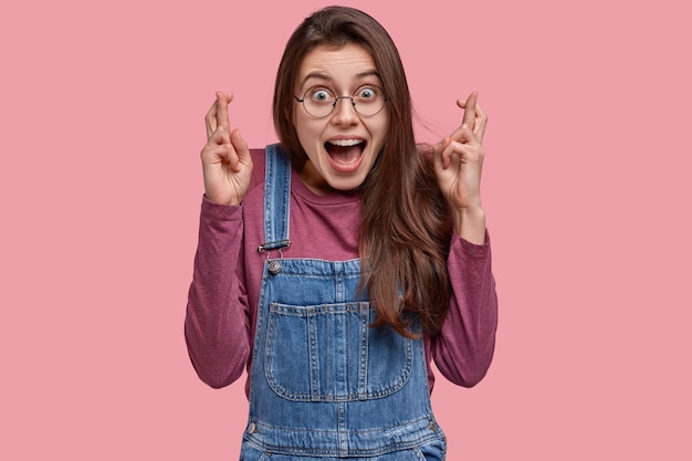 Jeune femme brune en salopette en denim