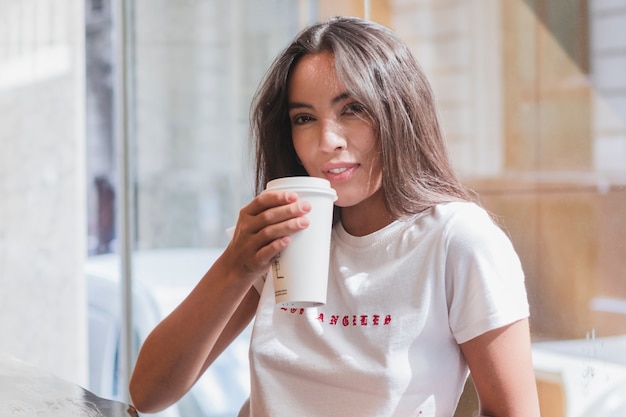 Jeune femme buvant le café au café