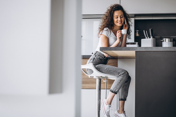 Photo gratuit une jeune femme buvant du café dans la cuisine.