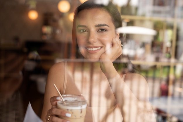 Jeune femme buvant du café glacé