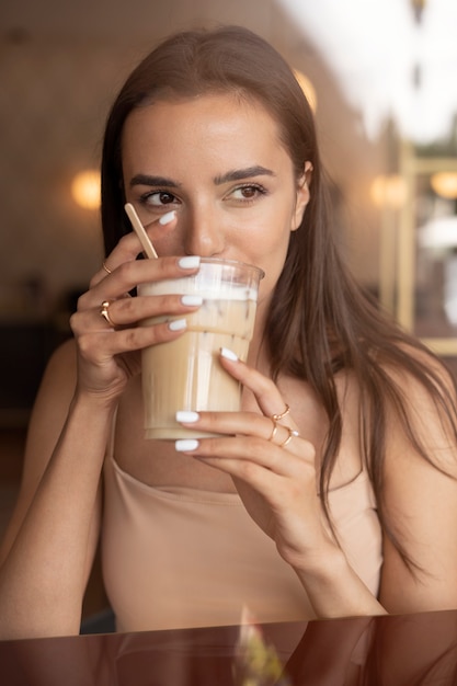 Jeune femme buvant du café glacé