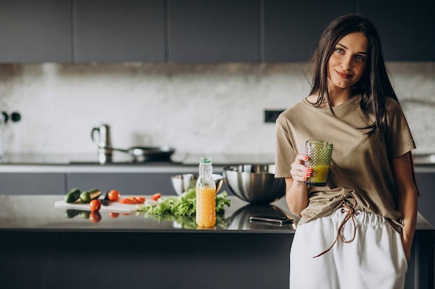 Jeune femme buvant du jus à la maison