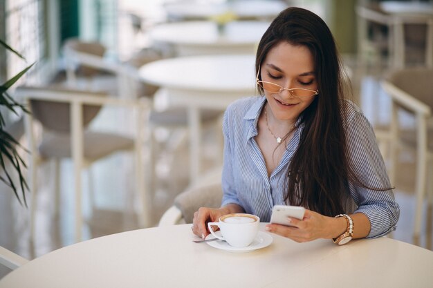 Jeune femme buvant du thé dans un café