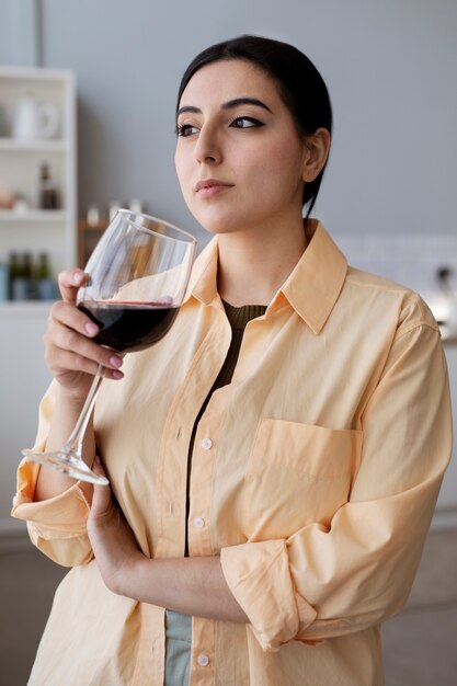 Jeune femme buvant du vin rouge