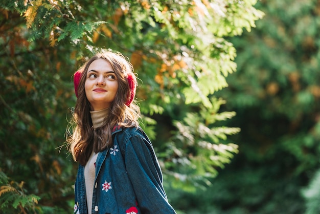 Jeune femme, cache-oreilles, près, rameaux verts