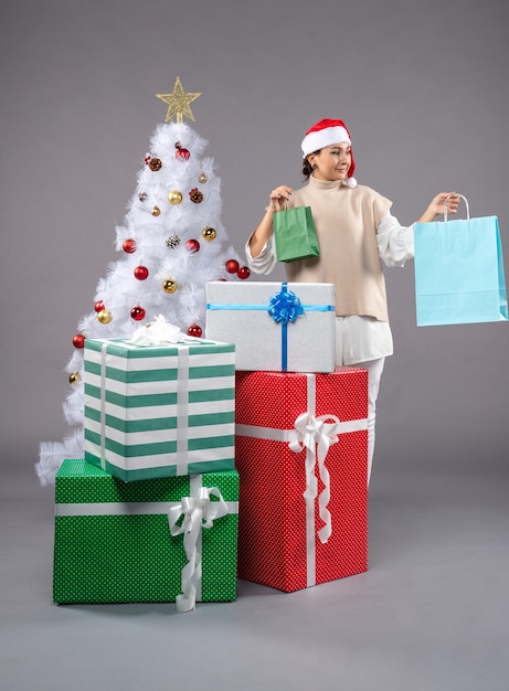 Photo gratuite jeune femme avec des cadeaux de noël sur la lumière