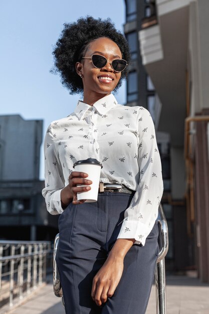 Jeune femme avec café sur le balcon