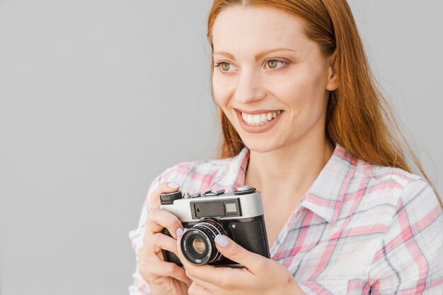 Jeune femme avec une caméra en studio