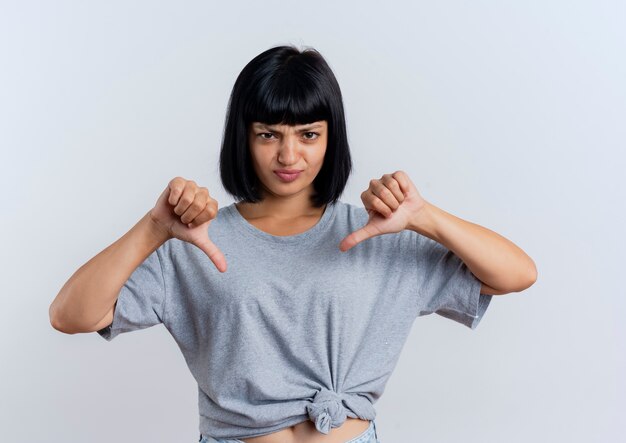 Jeune femme caucasienne brune agacée, les pouces vers le bas avec les deux mains