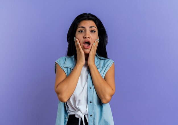 Une jeune femme caucasienne choquée met les mains sur le visage