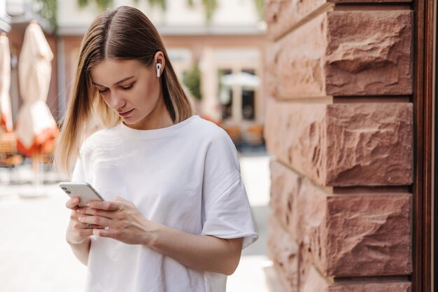 Une jeune femme caucasienne discute sur un smartphone