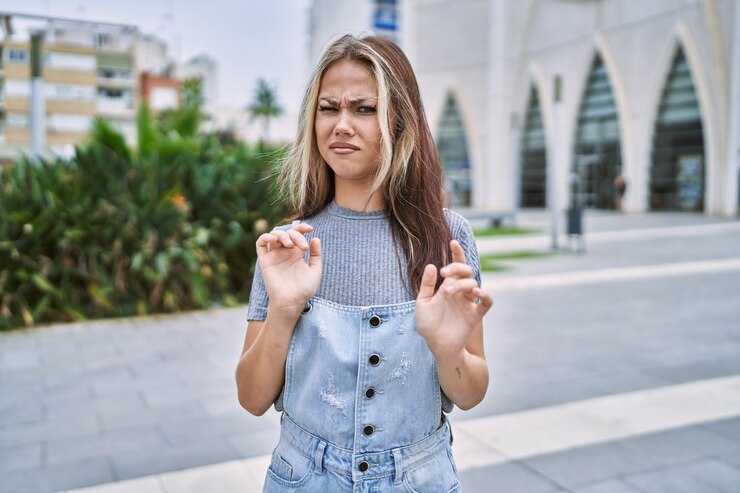 Photo gratuit jeune femme caucasienne à l'extérieur expression dégoûtée, mécontente et effrayée faisant face au dégoût parce que la réaction d'aversion. avec les mains levées