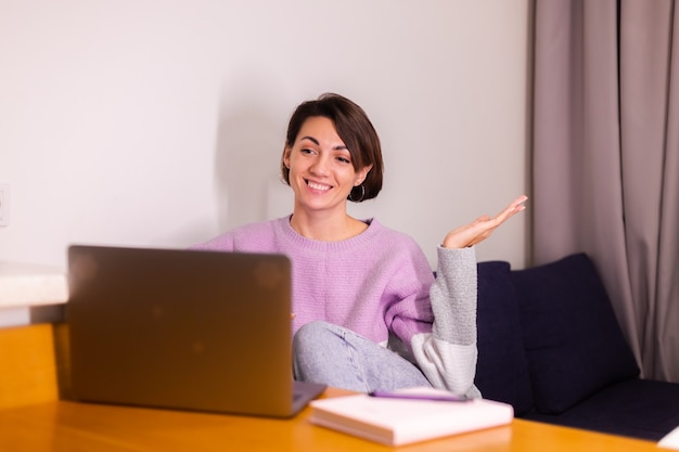 Jeune femme caucasienne sourire fille dans la chambre sur le canapé sourire caméra