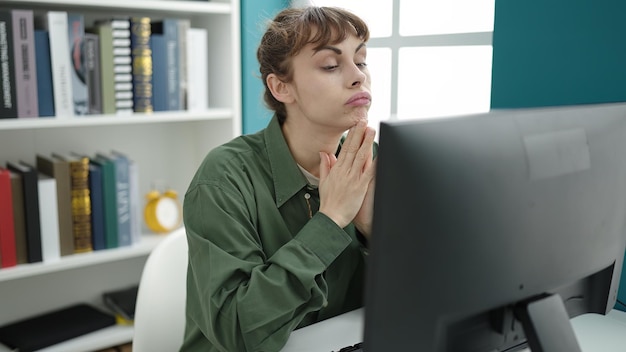 Photo gratuite jeune femme caucasienne utilisant un ordinateur stressée et fatiguée à l'université de bibliothèque