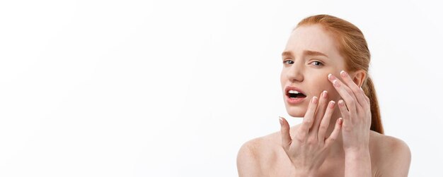 Jeune femme caucsienne serre l'acné sur le visage de la beauté