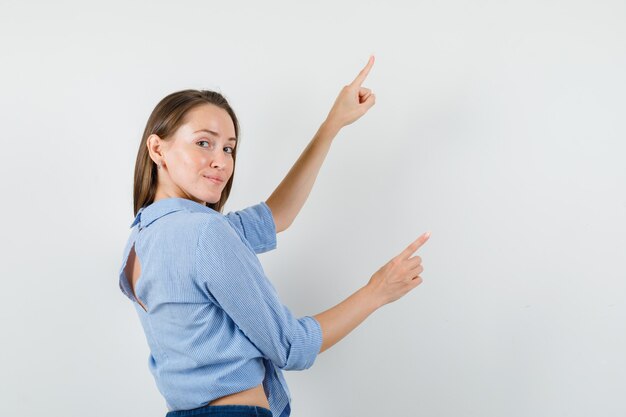 Jeune femme en chemise bleue, pantalon pointant vers le haut et à la joyeuse