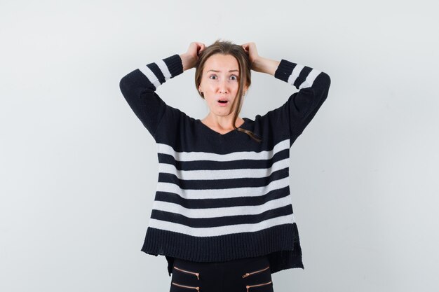 Jeune Femme En Chemise Décontractée, Gardant Les Mains Sur La Tête Et à La Nostalgie