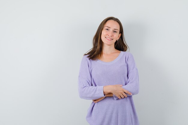 Jeune femme en chemise décontractée regardant la caméra et à la joyeuse