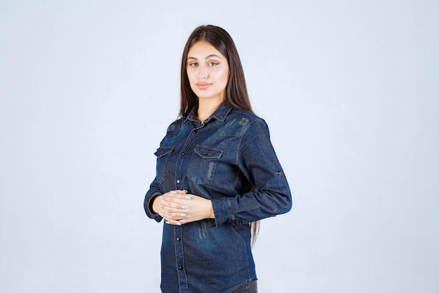 Jeune femme en chemise en jean donnant des poses neutres sans réactions