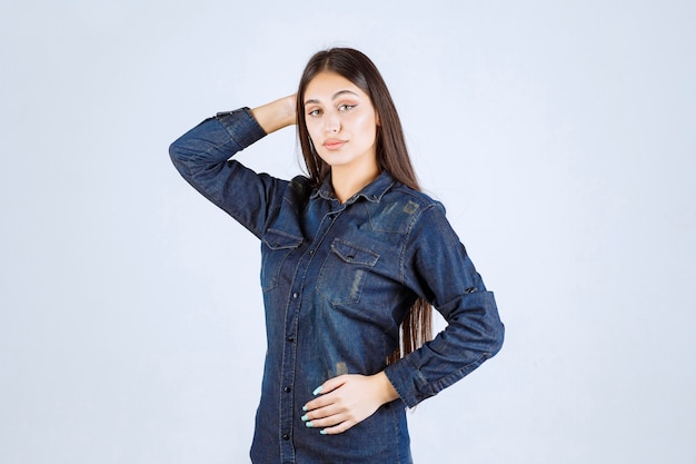 Jeune femme en chemise en jean donnant des poses neutres sans réactions