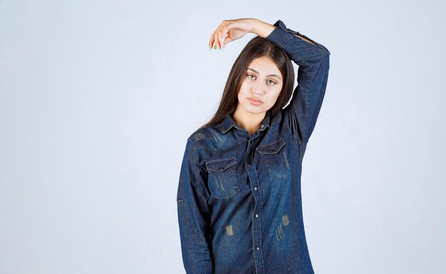 Jeune femme en chemise en jean donnant des poses neutres sans réactions