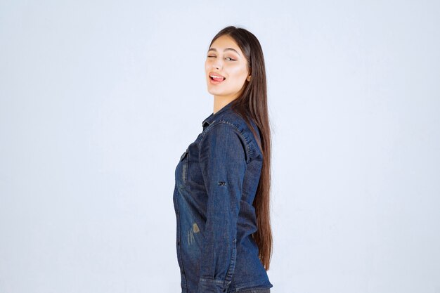 Jeune femme en chemise en jean donnant des poses neutres sans réactions