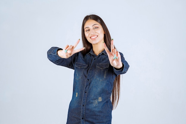 Jeune femme en chemise en jean souriant et faisant joli visage