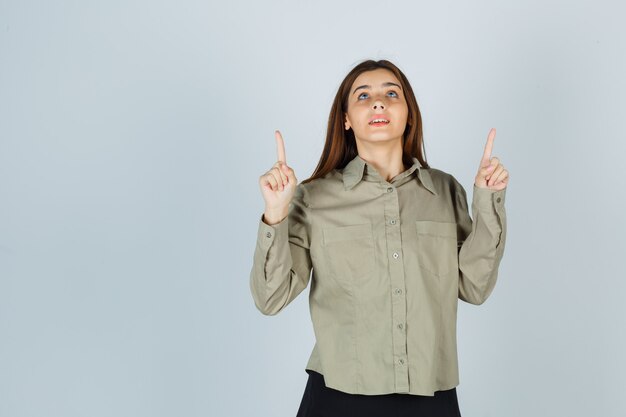 Jeune femme en chemise, jupe pointant vers le haut et à l'espoir, vue de face.