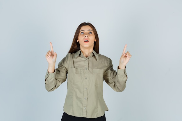 Jeune femme en chemise, jupe pointant vers le haut et à l'espoir, vue de face.