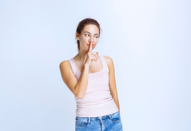 Jeune femme en chemise de sport demandant le silence