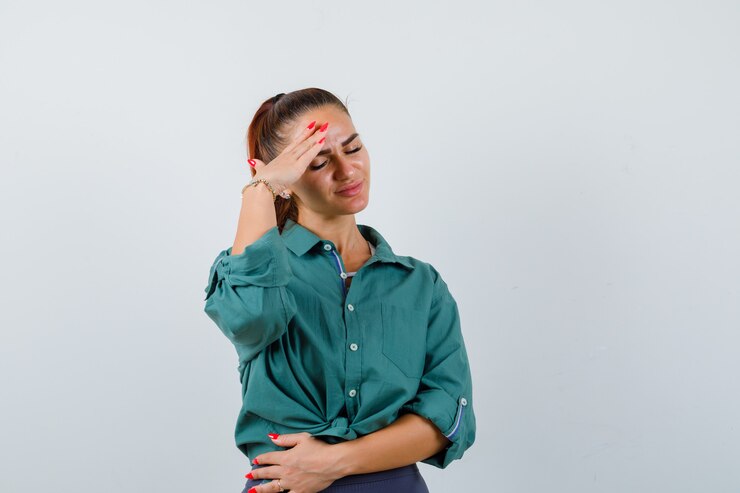 Photo gratuit jeune femme en chemise verte souffrant de migraine et semblant ennuyée, vue de face.