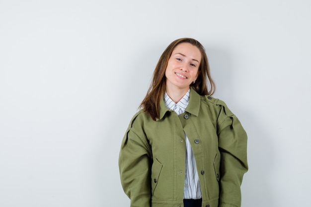 Jeune femme en chemise, veste regardant la caméra et semblant attrayante, vue de face.