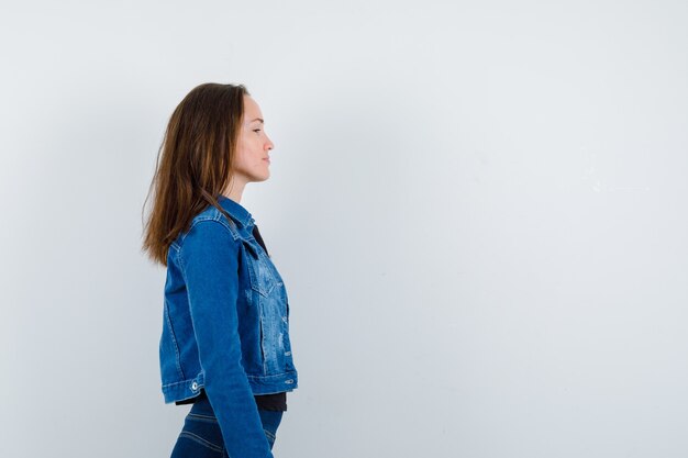 Jeune femme en chemisier regardant devant elle et ayant l'air calme.