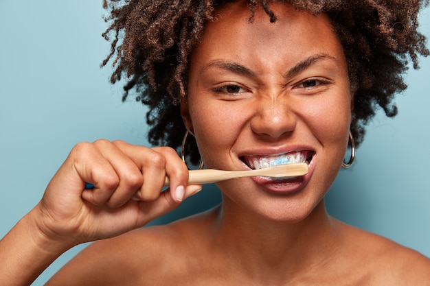 Photo gratuite jeune femme, à, cheveux bouclés, tenue, brosse dent