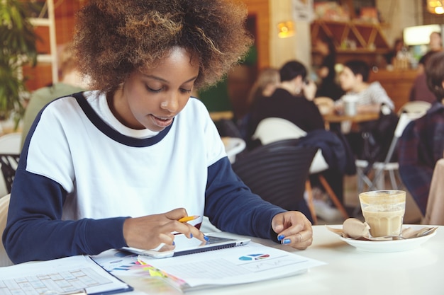 Jeune femme, à, cheveux bouclés, utilisation, tablette, dans, café