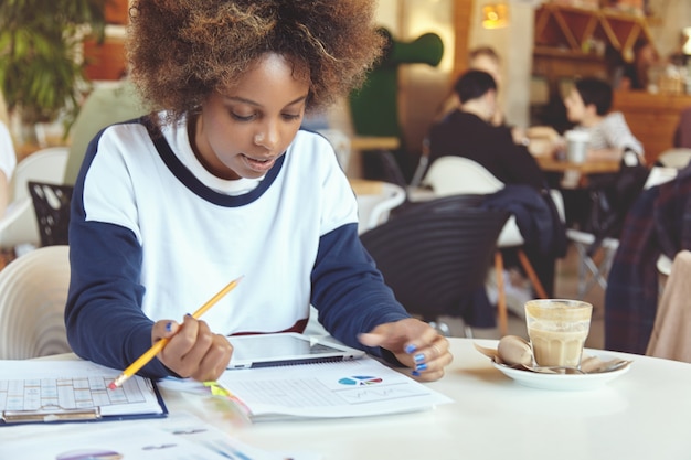 Jeune femme, à, cheveux bouclés, utilisation, tablette, dans, café