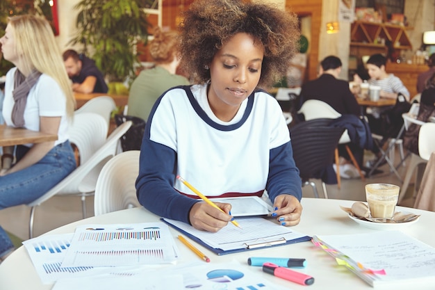 Jeune femme, à, cheveux bouclés, utilisation, tablette, dans, café