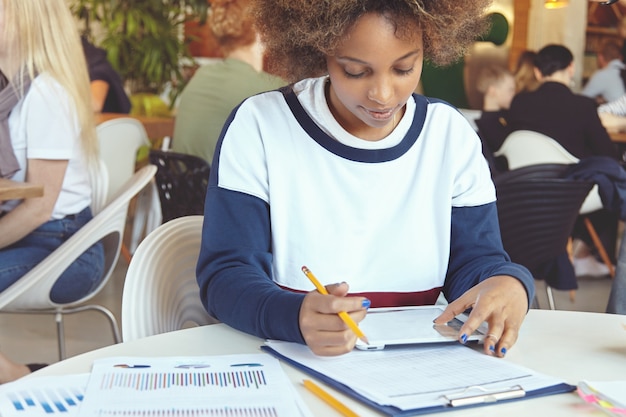 Jeune femme, à, cheveux bouclés, utilisation, tablette, dans, café