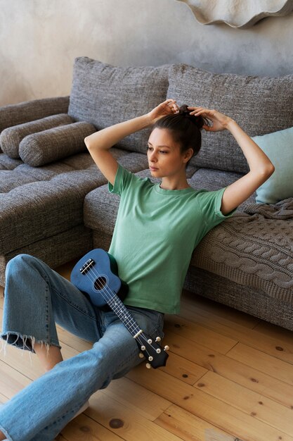 Jeune femme avec chignon désordonné jouant du ukulélé