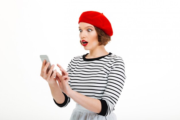 Jeune femme choquée discutant par téléphone mobile
