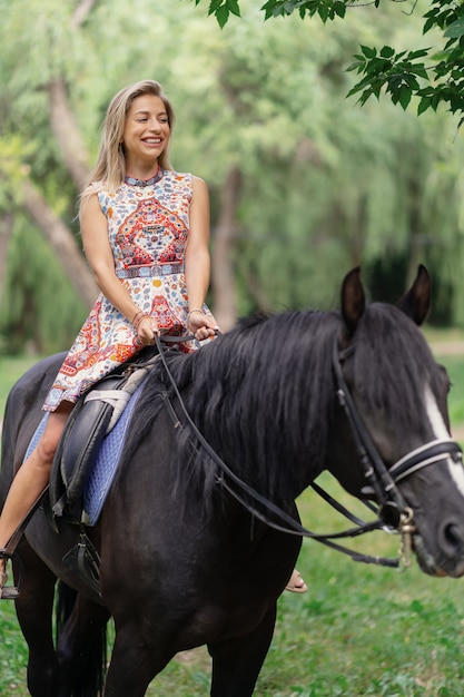 Photo gratuite jeune, femme, clair, coloré, robe, équitation, noir, cheval