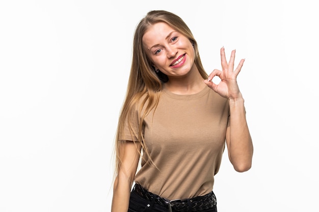 Jeune femme avec un clin d'œil OK geste isolé sur une surface blanche