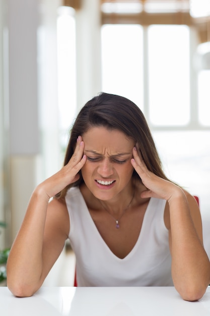 Jeune femme en colère frottant les tempes