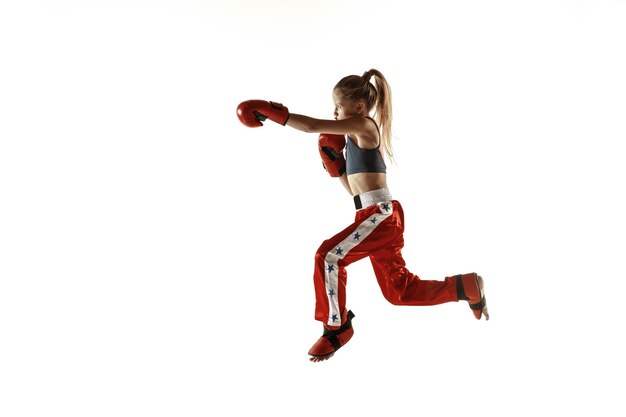 Jeune femme combattant de kickboxing s'entraînant sur blanc