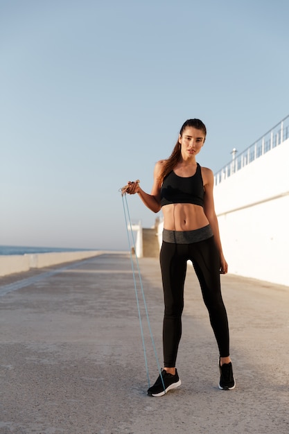 Jeune femme confiante de fitness formation près de la mer