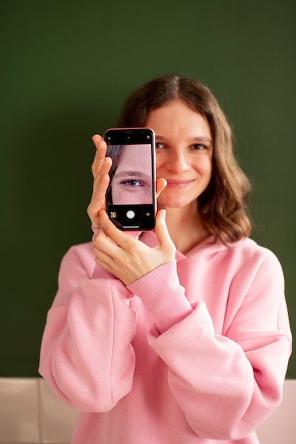 Photo gratuite jeune femme connectée à son smartphone