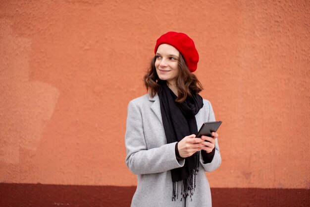 Photo gratuite jeune femme connectée à son smartphone