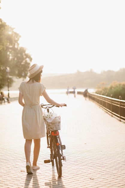 Jeune femme contre nature fond à vélo