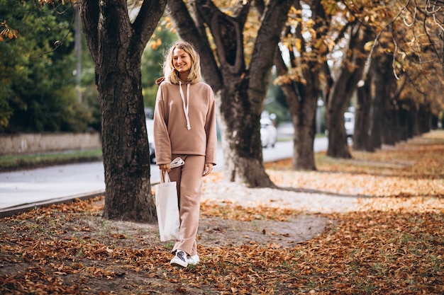 Jeune femme en costume beige à l'extérieur dans un parc en automne